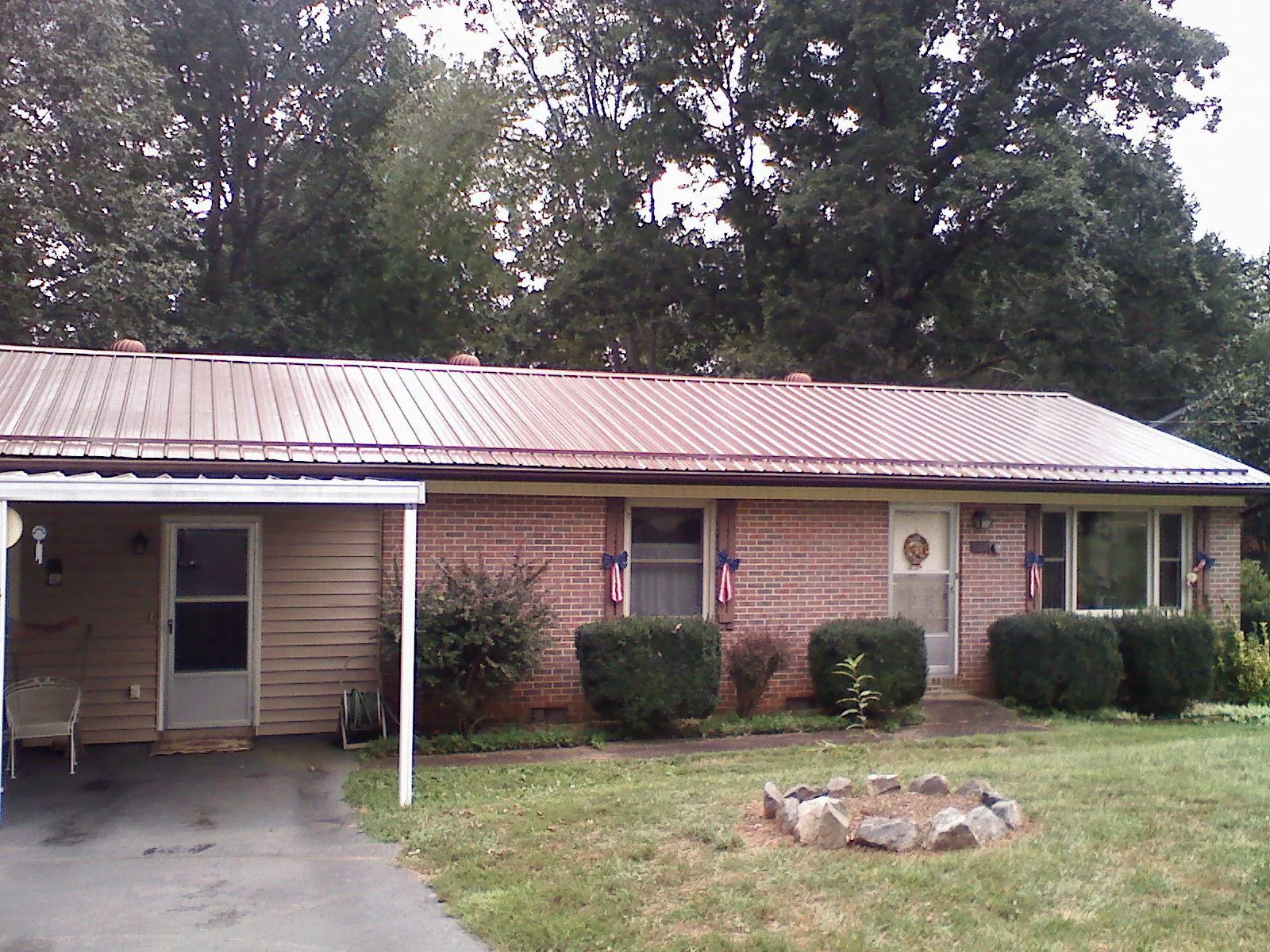 Bronze metal roof and carport on a brick ranch home — Roof Repair work by our crew in Adamsville